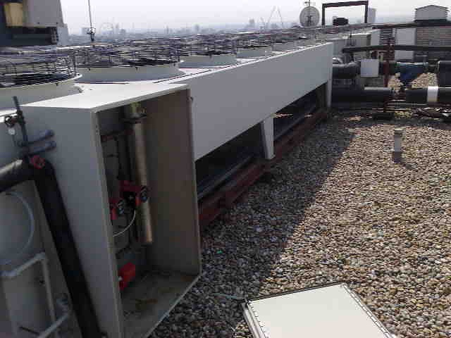 Dry cooler with panel lying beside it on the roof